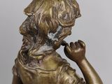 bronze figurine of a girl with a bird on her shoulder