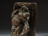 une image représentant une sculpture en bois d'un homme tenant un enfant dans ses bras