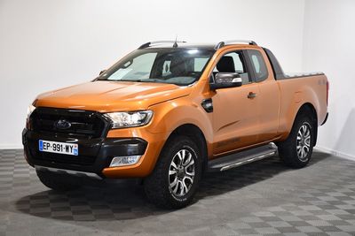 La camionnette orange est garée dans une pièce dont le sol est en damier.