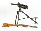an old gun and a rifle on a tripod stand on a white background