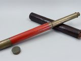 a red and gold pen sitting on top of a white table