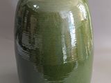 a green vase that is sitting on a table