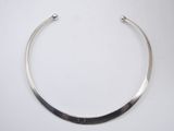a close up of a silver necklace on a white surface