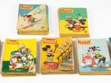 Six livres de Mickey Mouse sont alignés sur une surface blanche