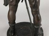 statue of a man with a gun and a hat on a base
