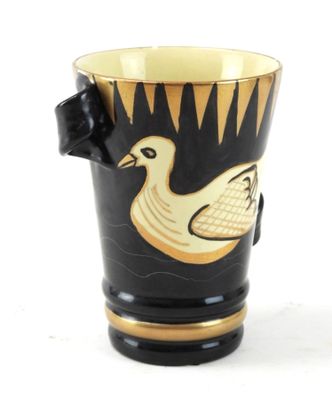 une tasse noire et dorée sur laquelle est représenté un canard