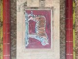 painting of a tiger in a red frame on a wall