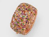 gros plan d'une bague en or avec des pierres multicolores