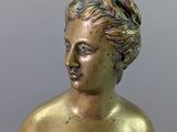 bronze statue of a woman with her hands on her chest