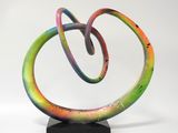sculpture composée de spirales multicolores sur un socle noir, se détachant sur un fond blanc