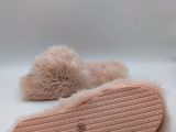 pink slippers with fur on them sitting on top of a white surface