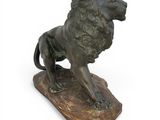 bronze statue of a lion on a rock on a white background