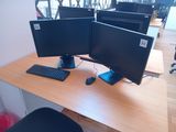 two computer monitors and a keyboard on a desk