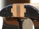 a black vase with a wooden handle on a table