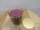 candles are sitting on a wooden table next to a glass