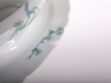 a close up of a white toilet with blue flowers on it