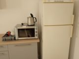 a small kitchen with a microwave and a refrigerator in it
