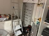 une pièce dans laquelle se trouvent une échelle, une chaise et un téléviseur