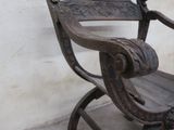 a wooden chair that is sitting against a white wall