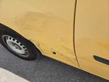 a yellow car that has a hole in the side of it