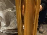 a gold vase that is sitting on the floor
