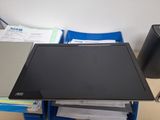 a laptop computer sitting on top of a desk next to a stack of papers