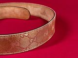 a close up of a belt with a buckle on it on a red surface
