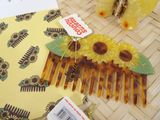 a yellow comb with flowers on it sitting on a table