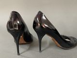pair of black high heeled shoes on a grey surface