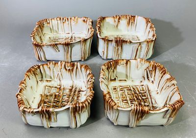 quatre bols en céramique marron et blancs posés sur une table