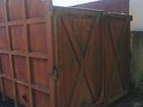 a large wooden box sitting on the side of the road