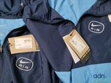 a blue jacket with a tag on it and a blue jacket with a tag on it