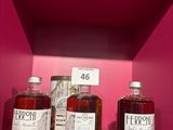 trois bouteilles d'alcool sont posées sur une étagère dans un magasin