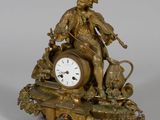 une horloge en bronze sur laquelle sont représentés un homme et un chien