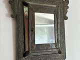 un miroir accroché au mur dans lequel on voit un livre
