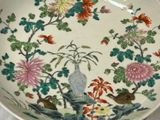 a plate with flowers and birds on it on a table