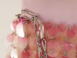 a pink purse with a chain hanging from it ' s side