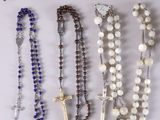 several rosary beads and a crucif cross on a table