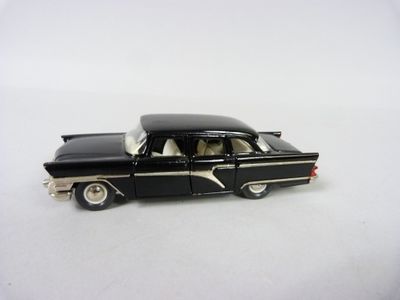 une petite voiture noire posée sur une surface blanche