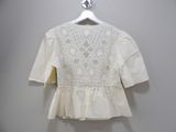 a close up of a white blouse on a hanger on a wall