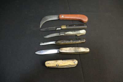several different types of knives are lined up on a black surface