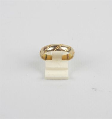gros plan d'une bague en or sur une surface blanche