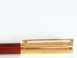 the pen is red and gold with a black tip