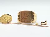 a gold ring and a gold coin on a white surface