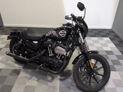 une moto garée sur un sol en carrelage à damier dans une pièce
