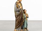statue of jesus holding a child in his arms and standing next to him