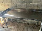 une table en acier inoxydable avec un plateau et des pieds en métal