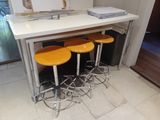 quatre tabourets placés devant un comptoir muni d'un miroir