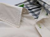 the shirt is white and has a checkered collar and cuffs
