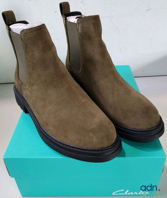 a pair of brown sued chelsea boots on top of a blue box